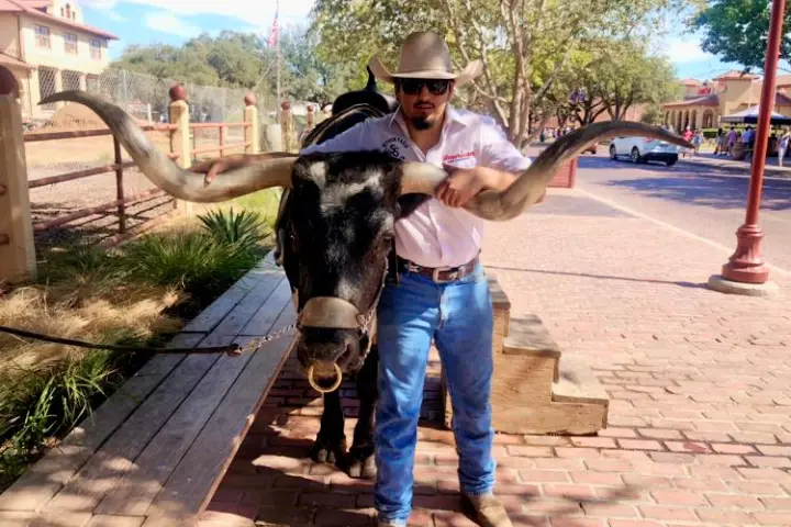 a man holding a skateboard on a sidewalk