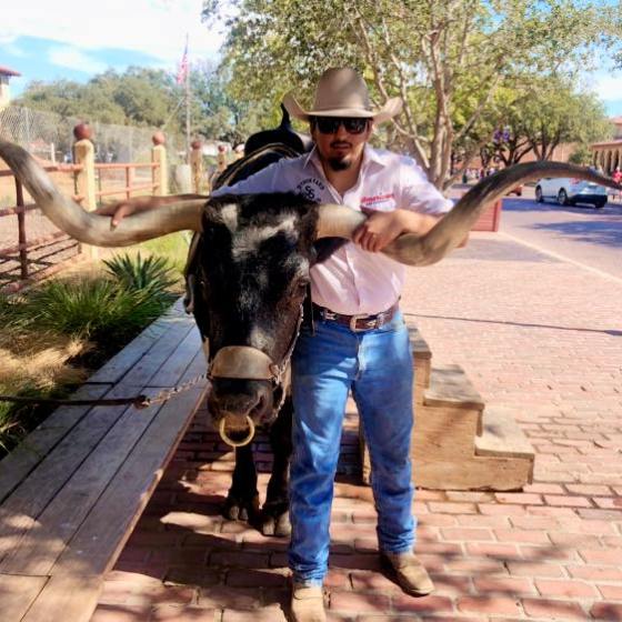 a man holding a skateboard on a sidewalk